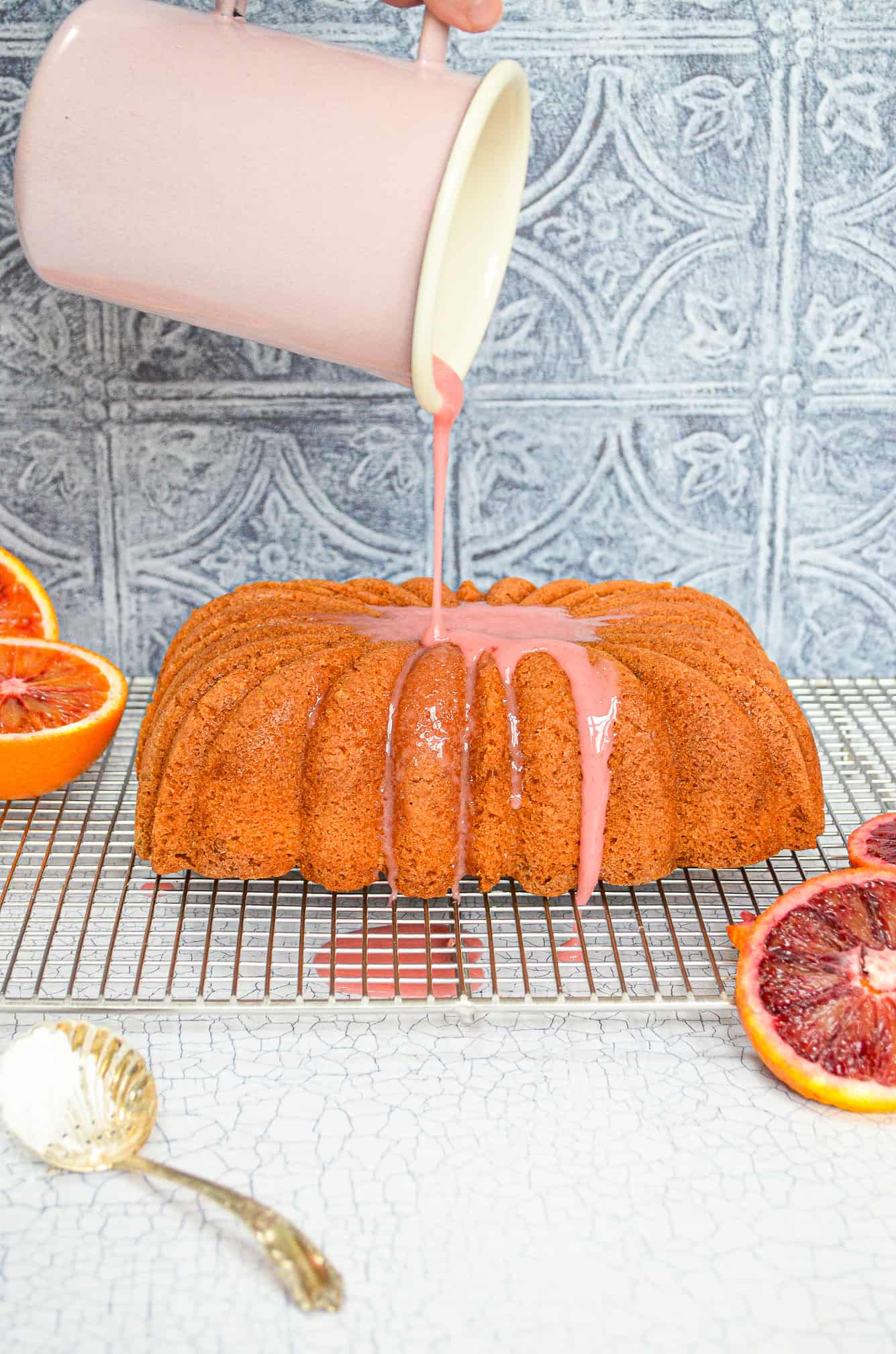 blood orange loaf cake with glaze being poured on top