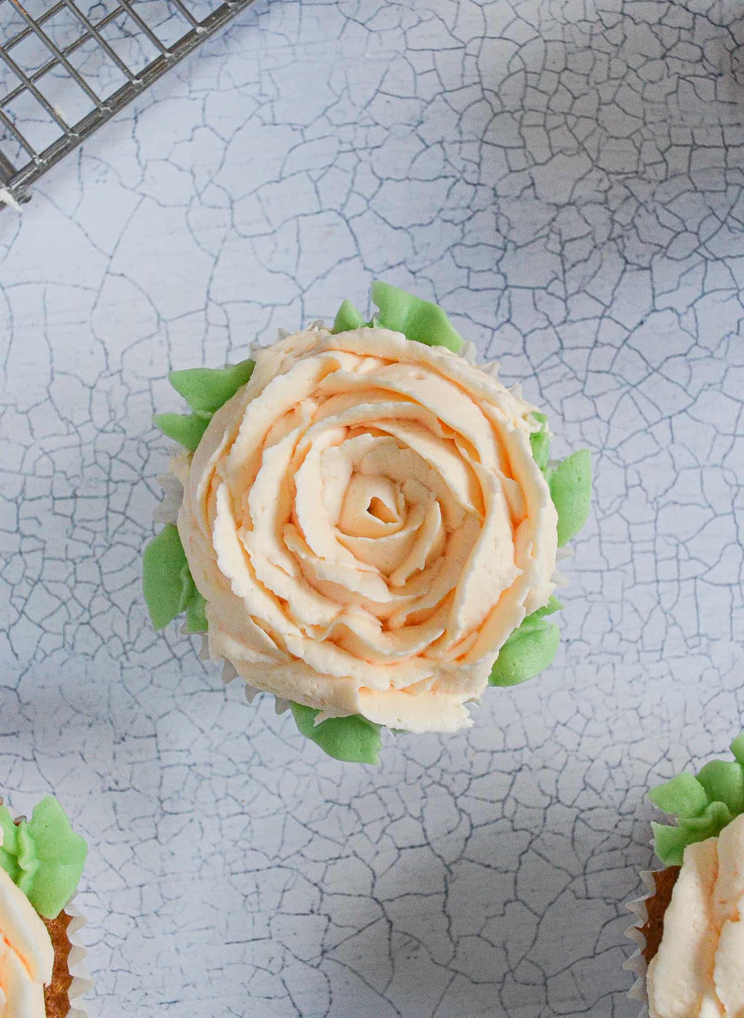 closeup of buttercream flower rose cupcake with leaves